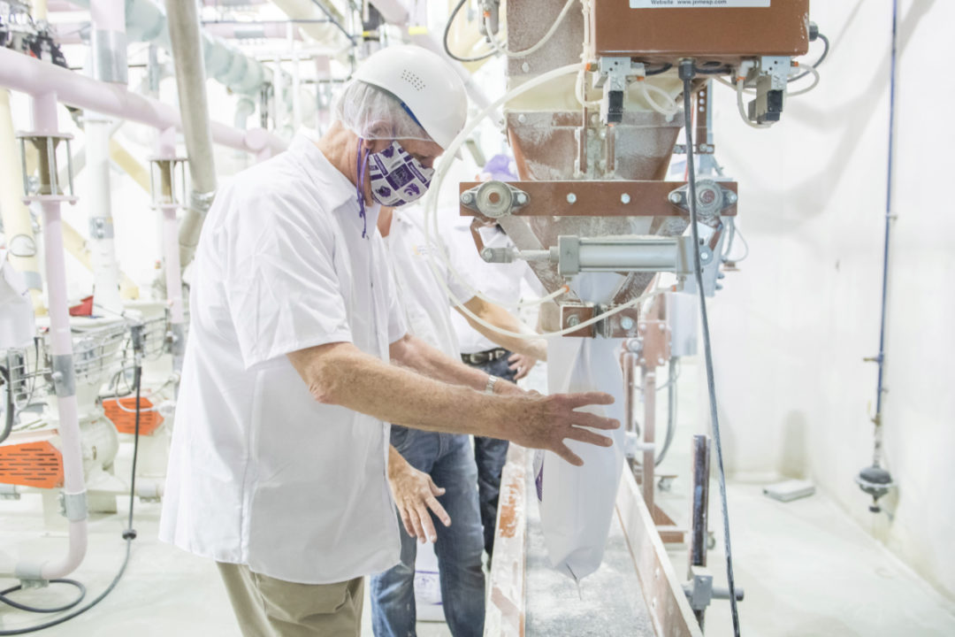 Richard Myers, president of Kansas State University, assists with the flour production on June 4 at the Hal Ross Flour Mill. Photos courtesy of KSU.