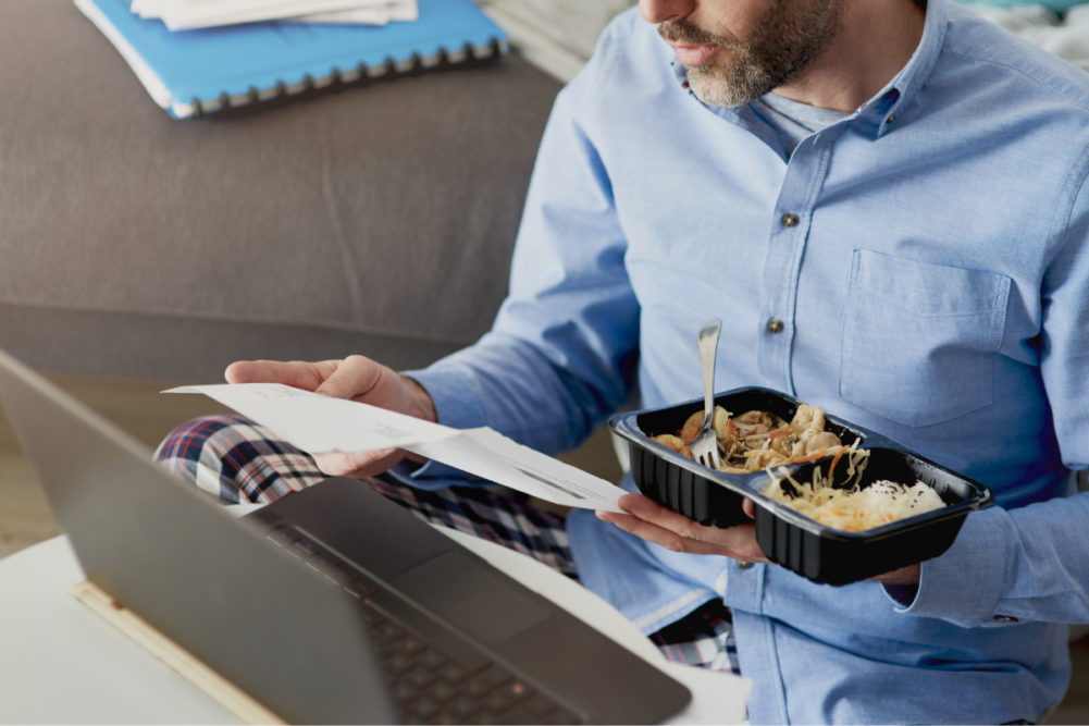Man working from home and eating a microwaved meal