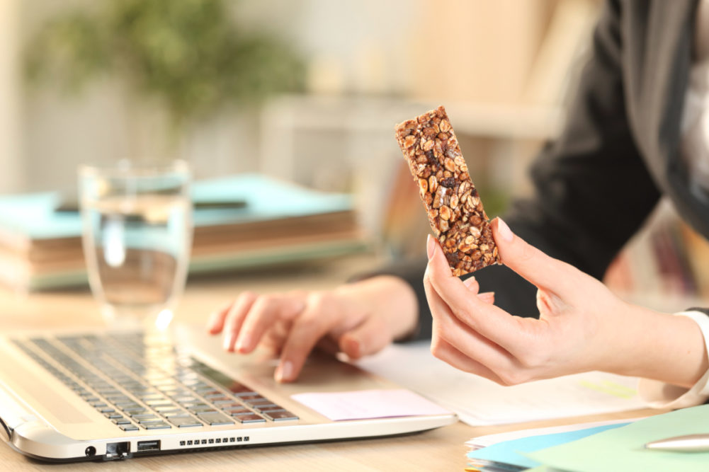 Eating granola bar for breakfast while working from home