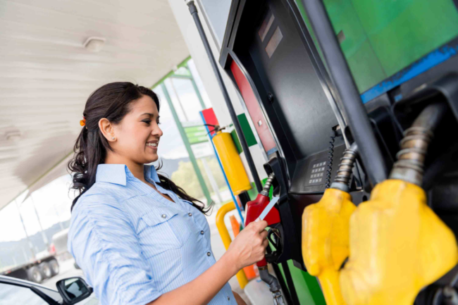 Woman refueling car at a gas pump 