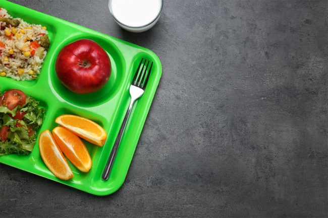 Green lunch tray, apple, orange slices
