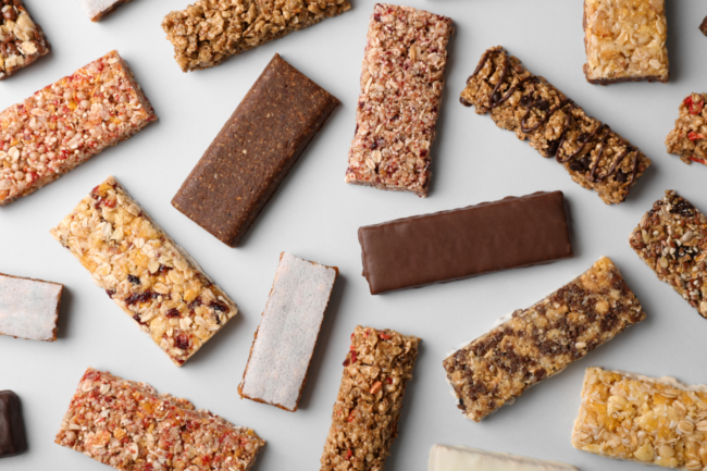 Flat lay composition with protein bars on grey background