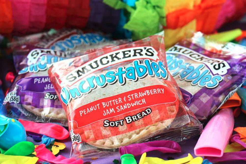 Smucker's Uncrustables on a pile of party supplies