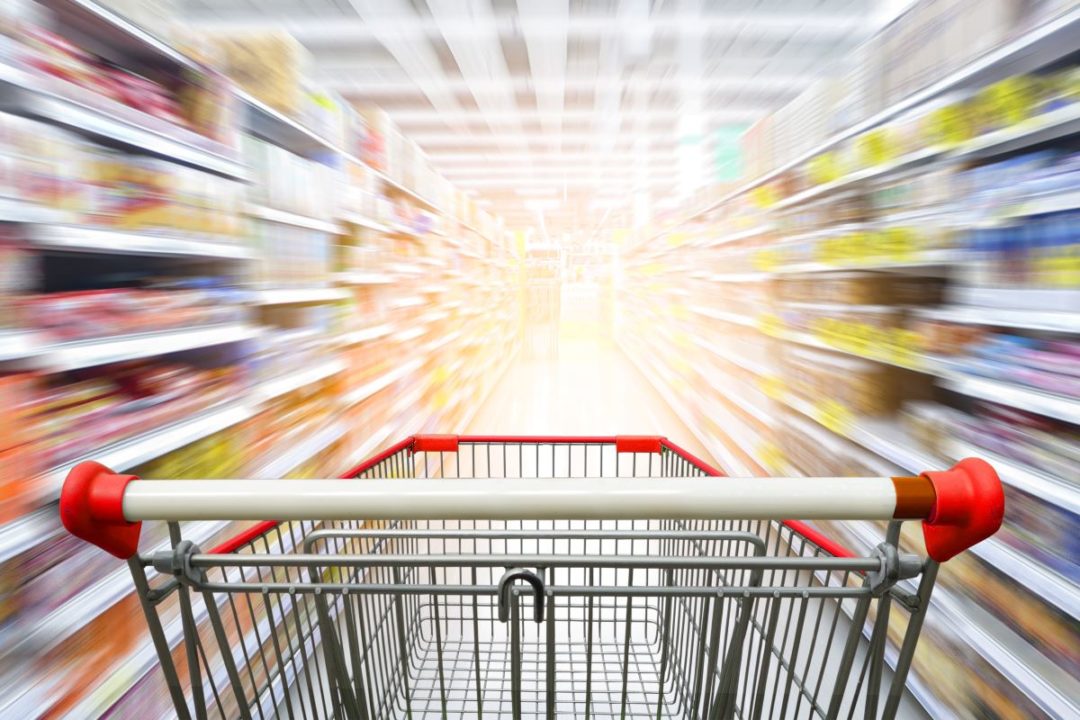 Shopping cart, blurred grocery store aisle