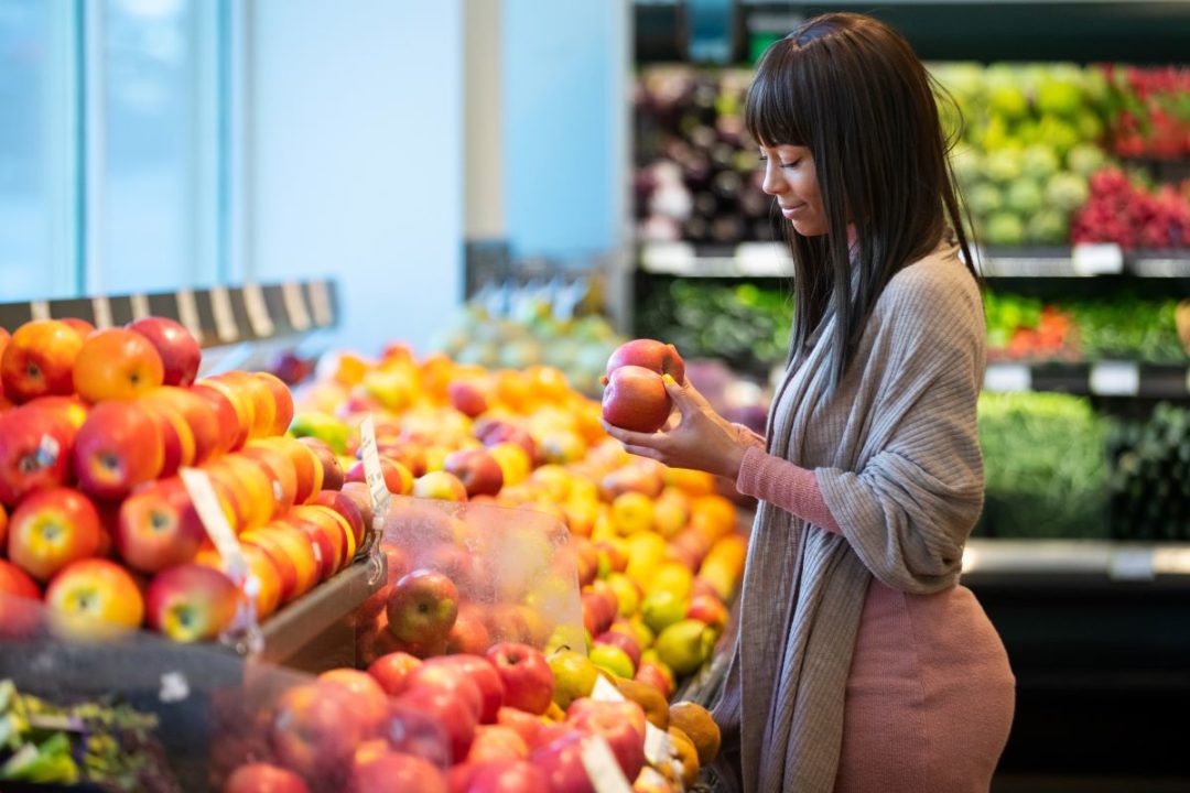 Shopper choosing produce, apples, grocery store