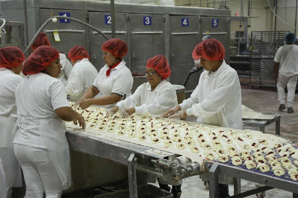 Workers assemble strawberry cheese knots, a pastry introduced a couple of years ago that is popular with customers.