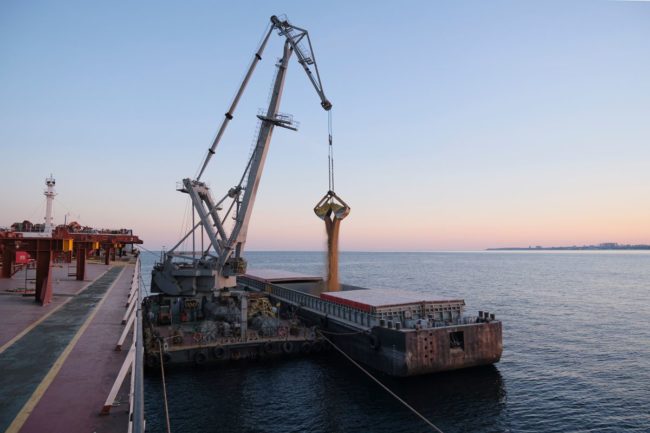 Loading grain on an ocean vessel, ship, ocean, crane, Adobe Stock