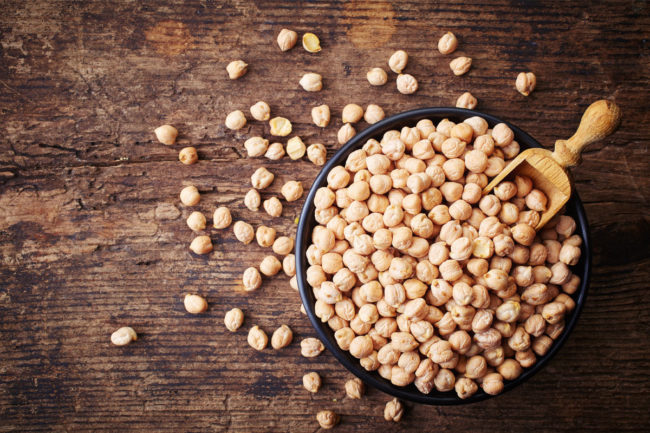 Chickpeas in a bowl, on wooden table