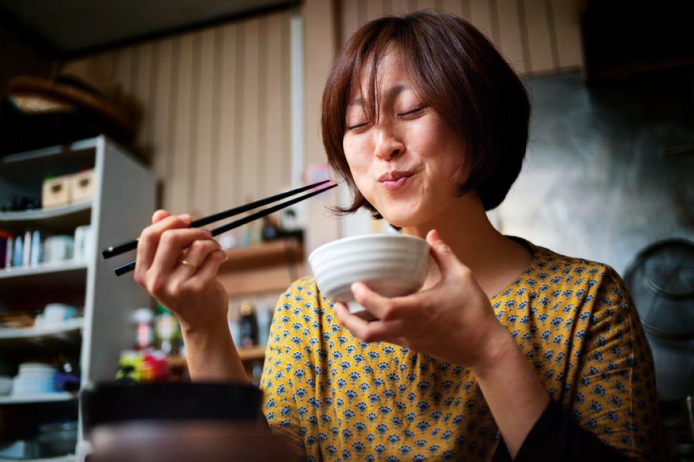 Woman enjoying food with chopsticks