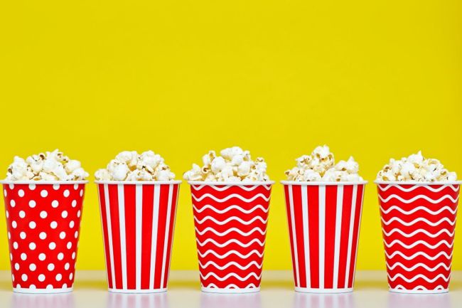 Buckets of popcorn, red and white buckets, yellow background