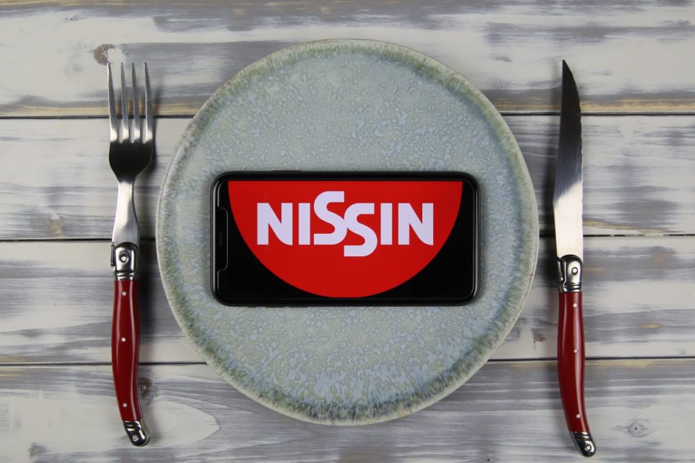 Nissin logo on a phone, dinner plate, fork and knife