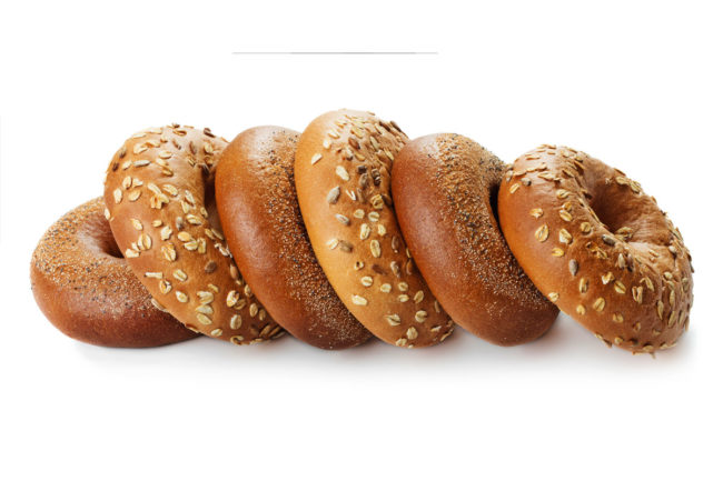 Assortment of various bagels on white background.