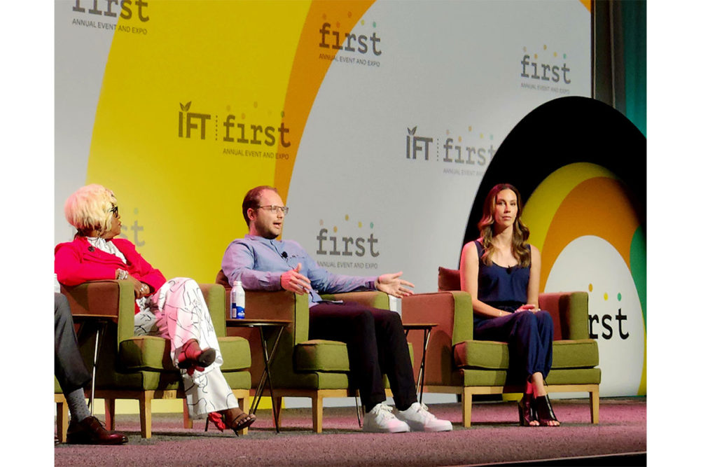 3 consumers sit on the IFT stage at a panel. 
