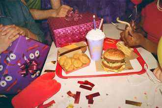 A group of people gather around to eat McDonald's. 