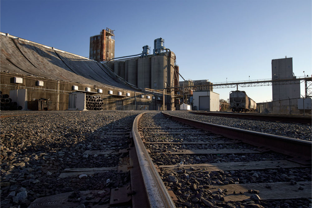 Large grain elevator outside on sunny day.