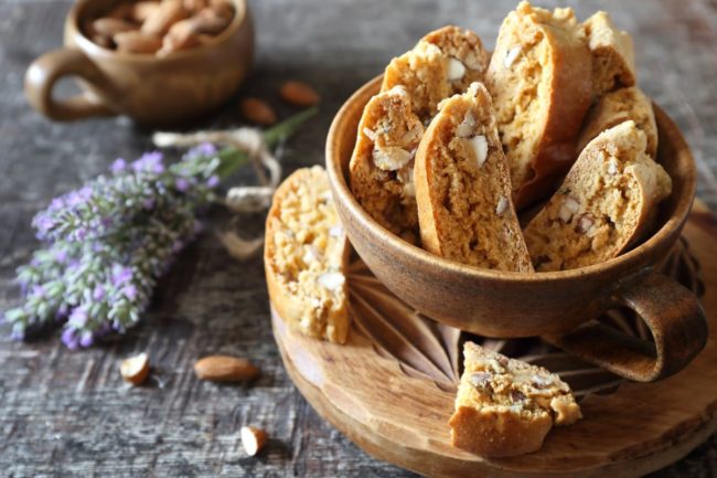A bowl of biscotti with lavender on the side. 