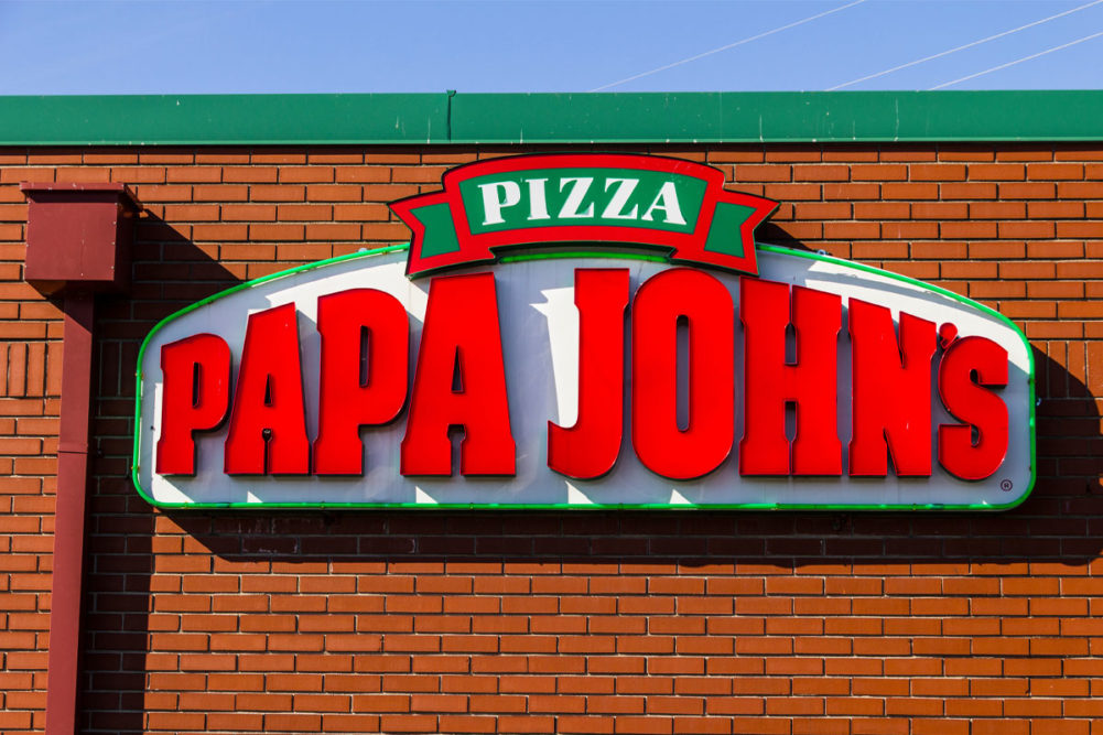 Papa Johns Logo over brick restaurant building. 
