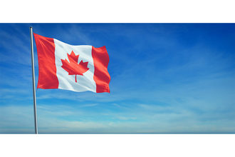 Candian flag blows in the wind on a beautiful sunny day. 