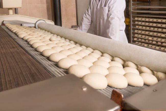 Baker with dozens of rolls.  