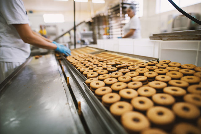 Bakery employees work an assembly line. 