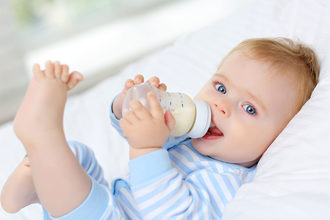 Baby drinking from bottle. 