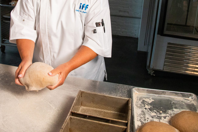 Baker from IFF kneads dough. 