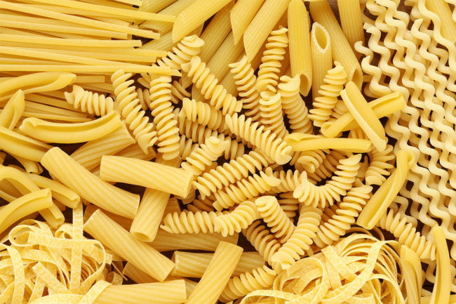 Assortment of uncooked pasta noodles including penne rigate and rotini.