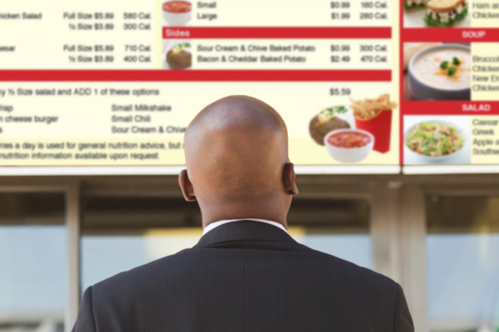 Man ordering from menu board with posted calories