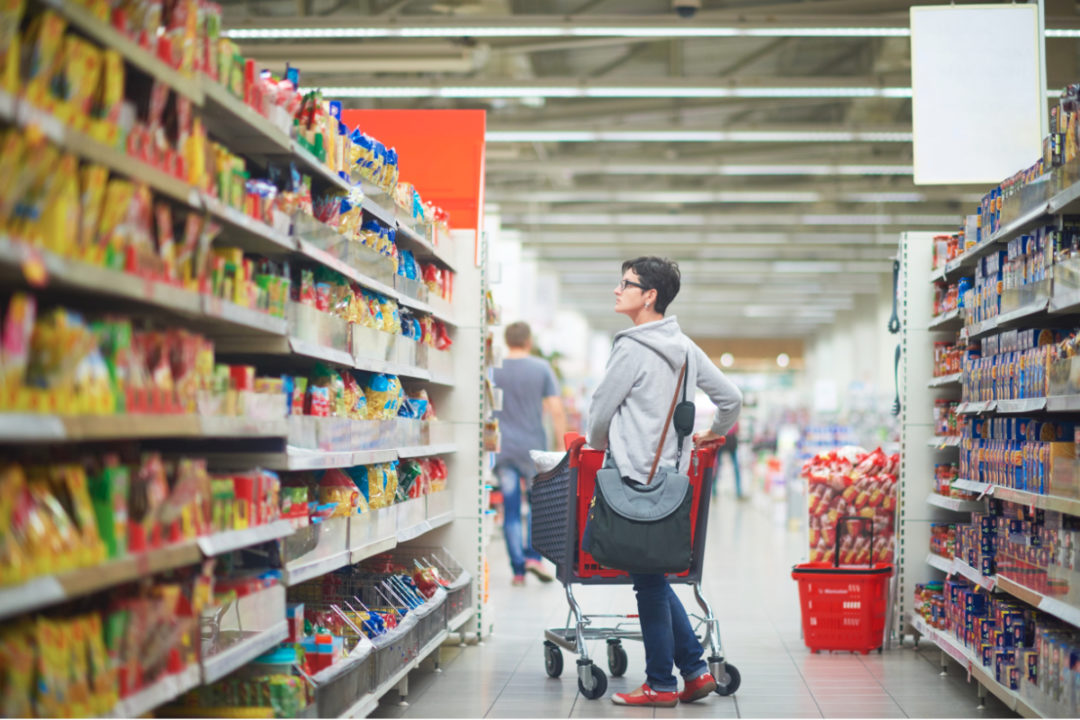 Woman scanning supermarket shelves